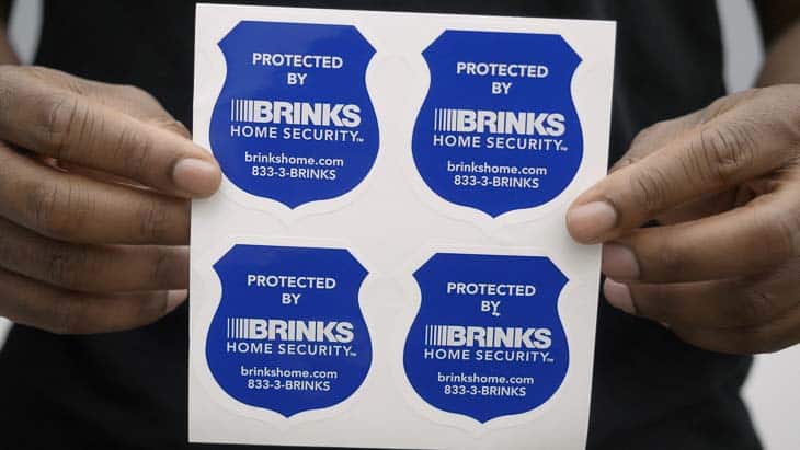 Brinks Stickers Brinks Home Security stickers held up by my colleague.
