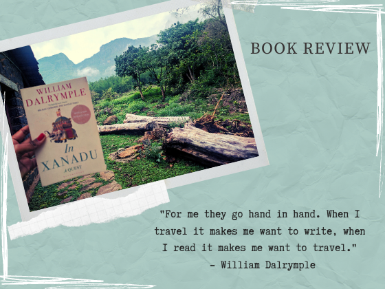 A hand holding the book Xanadu A quest by William Dalrymple. Background of fallen trees and mountains.